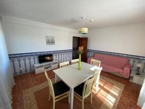 uma sala de estar com mesa, cadeiras e uma cama em Ericeira Sand Beach R6 na Ericeira