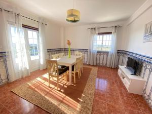 uma sala de jantar com uma mesa e uma TV em Ericeira Sand Beach R6 na Ericeira