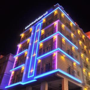 a building with blue and purple lights on it at Kinda Suites in Taif