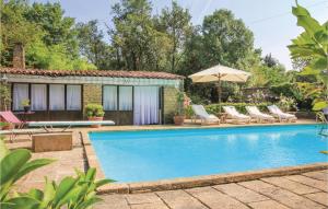 ランソン・プロバンスにあるNice Home In Lanon De Provence With 2 Bedrooms, Wifi And Outdoor Swimming Poolの裏庭のスイミングプール(椅子、パラソル付)