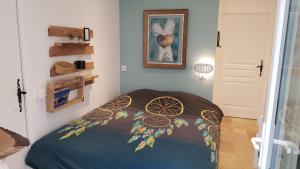 a bedroom with a bed with a colorful bedspread at Maison au calme en campagne climatisée in Caderousse