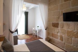 a bedroom with a bed and a stone wall at My Rooms Ciutadella Adults Only by My Rooms Hotels TI in Ciutadella