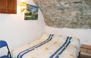 ラボームにあるStunning Apartment In La Beaume With 1 Bedroomsの石壁のベッドルーム1室(ベッド1台付)