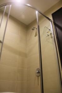 a shower with a glass door in a bathroom at My Inn Hotel in Tawau