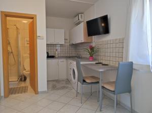 a kitchen with a table and chairs and a sink at Studio Sonja in Piran