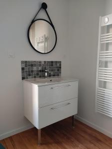 een badkamer met een witte dressoir en een spiegel bij Gite le Biardais in Balleroy