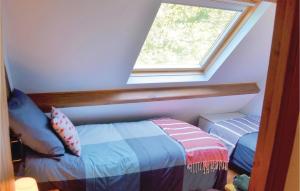 Zimmer im Dachgeschoss mit einem Bett und einem Fenster in der Unterkunft Beautiful Home In Ruffiac With 2 Bedrooms And Wifi in Ruffiac
