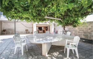 einen Betontisch und Stühle unter einem Baum in der Unterkunft Awesome Home In Caravaca With Kitchen in Caravaca de la Cruz