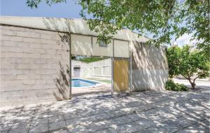 卡拉瓦卡德拉克魯斯的住宿－Awesome Home In Caravaca With Kitchen，白色砖砌的建筑,前面有一个游泳池