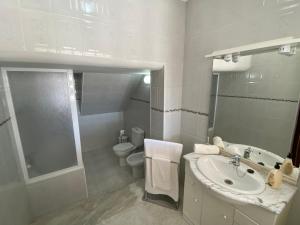 ein weißes Badezimmer mit Waschbecken und Toilette in der Unterkunft Ericeira Sand Beach RCT in Ericeira