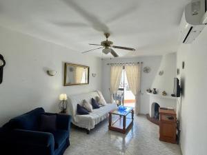 a living room with a couch and a ceiling fan at Apartment with Panoramic Views, San Juan de Capistrano, Nerja in Nerja