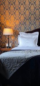 ein Bett mit einem Kissen und einer Lampe auf einem Tisch in der Unterkunft Brugsche Suites - Luxury Guesthouse in Brügge