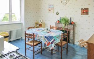 a dining room with a table with chairs and a fireplace at Awesome Home In Morlaix With 3 Bedrooms in Sainte-Geneviève