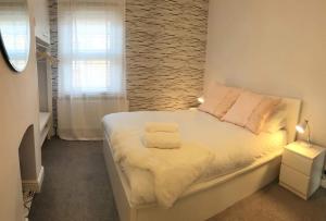 ein Schlafzimmer mit einem weißen Bett mit Ziegelwand in der Unterkunft Pass the Keys Central cosy home 5 minutes walk from Shrewsbury in Shrewsbury