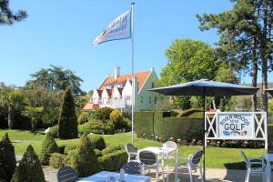 a table with an umbrella and a sign in a garden at Marie Siska Boutique hotel in Knokke-Heist