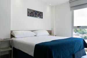 a bedroom with a bed with a blue blanket on it at Cinco Soles in Godoy Cruz