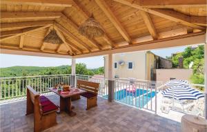 a patio with a table and chairs and a pool at 3 Bedroom Stunning Home In Babino Polje in Babino Polje