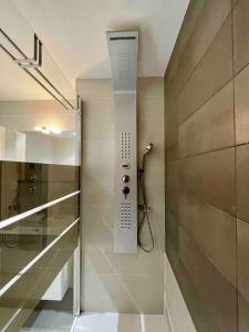 La salle de bains est pourvue d'une douche et d'un téléphone mural. dans l'établissement Superbe appartement, piscine, vue mer et montagnes, à Antibes