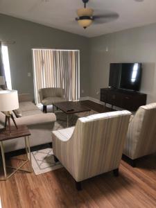 a living room with furniture and a flat screen tv at Cheerful 3 Bed house in a Cul- de-sac! in Tampa