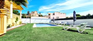 einen Garten mit Stühlen und einem Pool in der Unterkunft Agradable Villa con Piscina y BBQ. in San Vicente del Raspeig