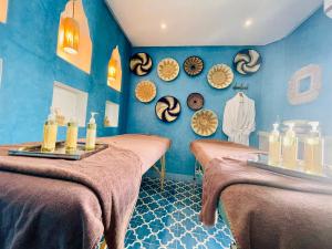 a blue room with two beds with candles on them at Maison Chafia Boutique Hôtel & Spa in Marrakech