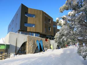 a building with blue skis in the snow at Buller Central Hotel in Mount Buller