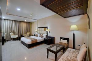 een hotelkamer met 2 bedden en een bank bij Hotel Floret Inn in Bhilai