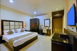 a bedroom with a bed and a desk in a room at Hotel Floret Inn in Bhilai