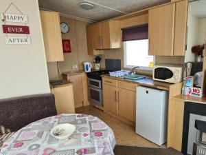 a small kitchen with a table in a caravan at 10 Berth on The Chase (Torbay) in Ingoldmells