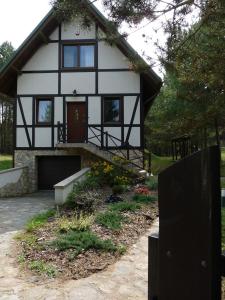 a white and black house with a yard at Raduńska Ostoja in Dziemiany