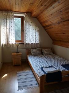 a small bedroom with a bed in a attic at Raduńska Ostoja in Dziemiany