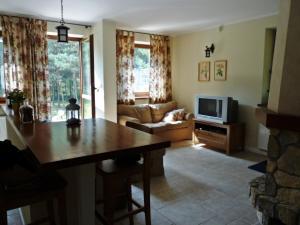 a living room with a table and a couch at Raduńska Ostoja in Dziemiany