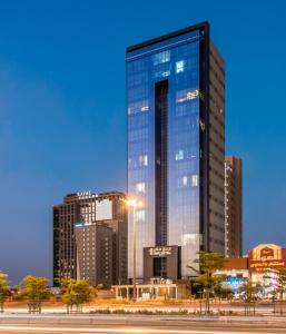 فندق عنان في الرياض: ناطحة سحاب زجاجية طويلة أمام المدينة