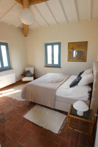 1 dormitorio con 1 cama grande en una habitación con ventanas en Casa La Selvella, en Gioiella