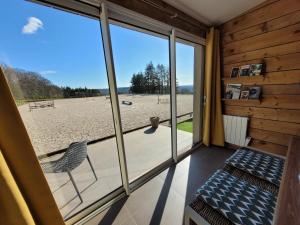 a room with a view of the beach through a sliding glass door at Le Cottage de la Doucette in Paimpont