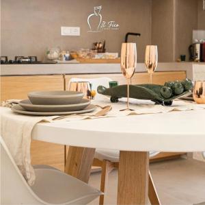 オストゥーニにあるIL Fico Luxury Home Ostuniの白いテーブル(皿、ワイングラス付)