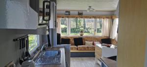 a kitchen and living room with a couch in a tiny house at Rosebud Flower Farm Caravan Stay Countryside And Coast in Penzance