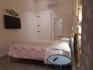 敘拉古的住宿－Casa Maria，一间卧室配有一张床、一张桌子和一台电视。