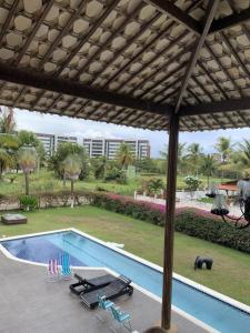 - une vue sur la piscine dotée de chaises et d'un parasol dans l'établissement Casa Branca do Paiva, à Cabo de Santo Agostinho