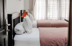 ein Schlafzimmer mit 3 Betten und Kissen darauf in der Unterkunft Pasola Guest House in Medan