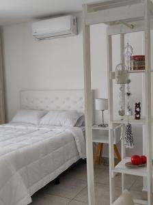 a white bedroom with a bed and a desk at Cabrera in Junín