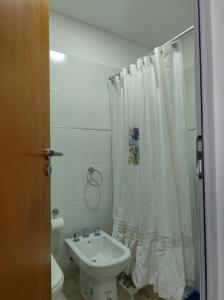 a bathroom with a white shower curtain and a sink at Cabrera in Junín