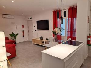LEVANTE SUITES في بنيدورم: غرفة معيشة مع ستائر حمراء وأريكة حمراء