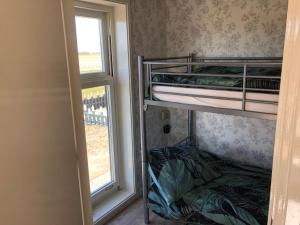 a room with two bunk beds next to a window at De Salon in Warmenhuizen