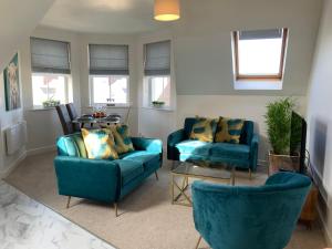 salon z 2 niebieskimi krzesłami i stołem w obiekcie Luxurious Loft Flat 2-bed/2-bath w mieście South Shields