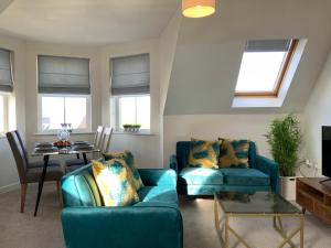 ein Wohnzimmer mit 2 blauen Sofas und einem Tisch in der Unterkunft Luxurious Loft Flat 2-bed/2-bath in South Shields