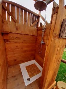 Cette dépendance en bois dispose d'une douche au milieu. dans l'établissement LA HUTTE MASSAÏ, à Villelaure