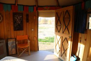 una puerta abierta a una habitación con una silla naranja en LA HUTTE MASSAÏ, en Villelaure