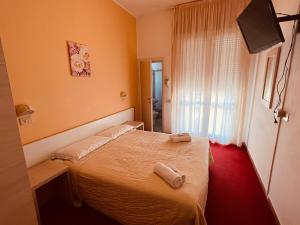 a bedroom with a bed with two towels on it at Villa Silvie Rose in Cesenatico