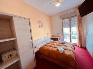 a hotel room with two beds and a window at Villa Silvie Rose in Cesenatico